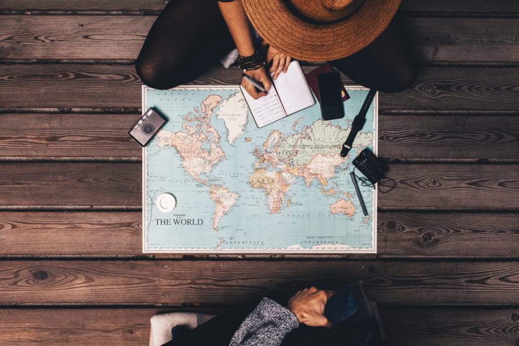 Man,and,woman,planning,vacation,using,a,world,map